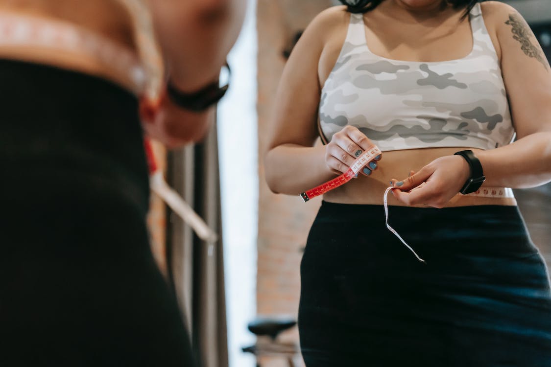 a person measuring their waist