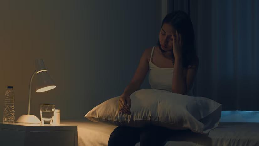 Young woman holding medications for sleep disturbances